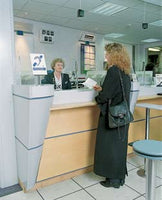 Woman speaking to someone at a counter with the Contact Under The Counter Loop system