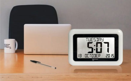 The Viso10 alarm clock on a desk with a laptop, mug and pen. Chair in the background